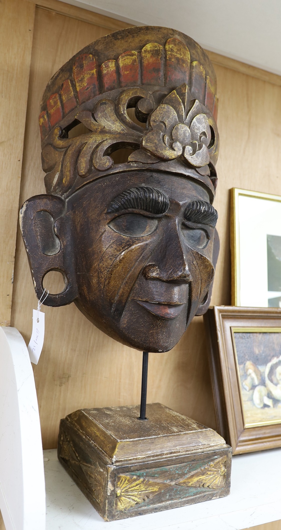 A large Asian carved wood mask on stand 66cm